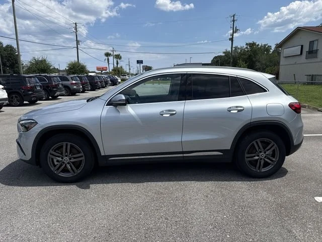 Silver Mercedes-Benz GLA on the lot with the dealership sign behind it