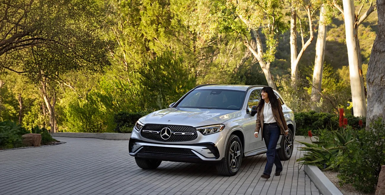 Mercedes-Benz GLC on a tree-lined drive, the size-down option we steer shoppers toward when the GLS is more vehicle than they need