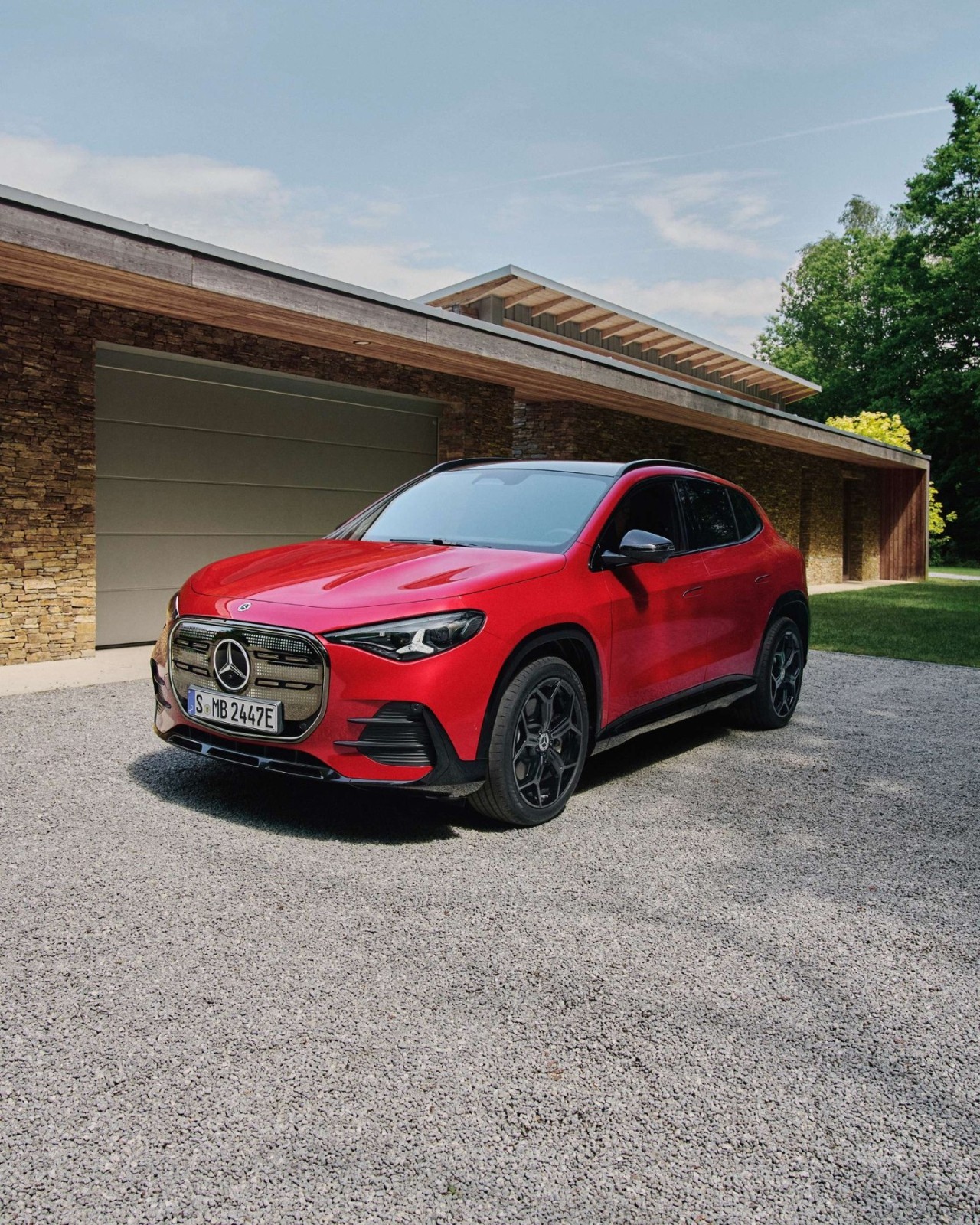 Red Mercedes-Benz EQA electric SUV parked in front of a modern home, showcasing its premium design and available for a test drive at Mercedes-Benz of Fort Walton Beach.