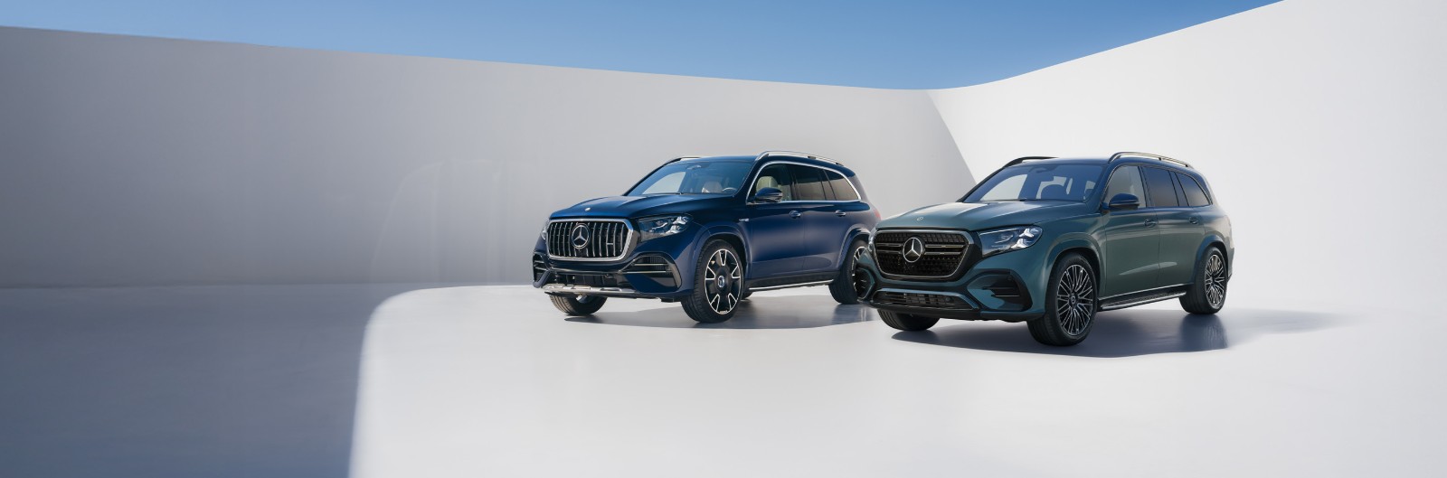 Two Mercedes-Benz GLS SUVs side by side on a studio backdrop